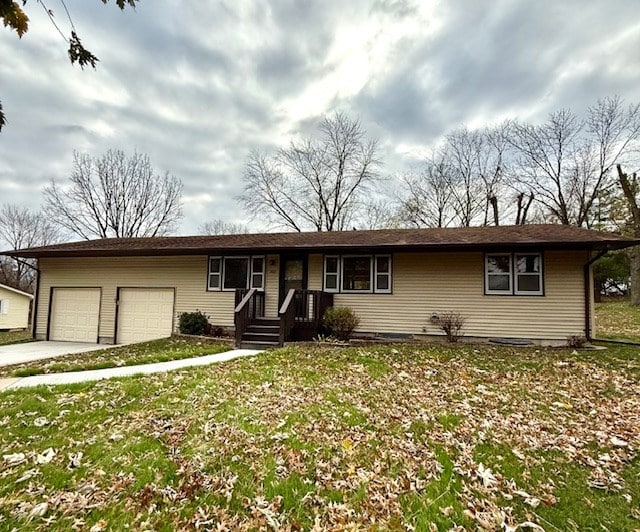 single story home with a garage and a front lawn