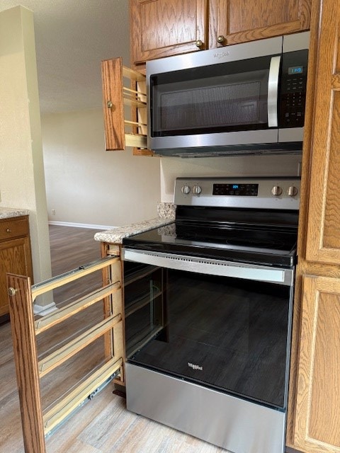 kitchen with light wood-type flooring and appliances with stainless steel finishes