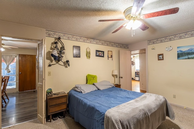 carpeted bedroom featuring a textured ceiling and ceiling fan