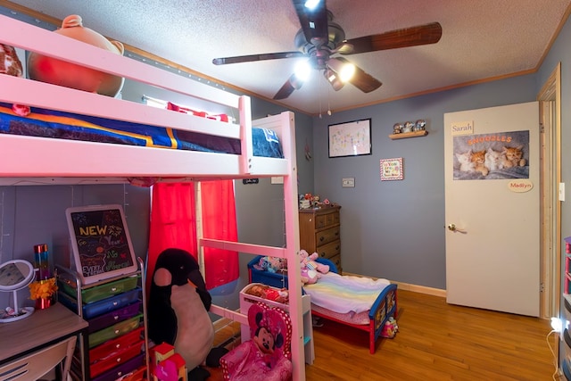 bedroom with hardwood / wood-style flooring, a textured ceiling, and ceiling fan