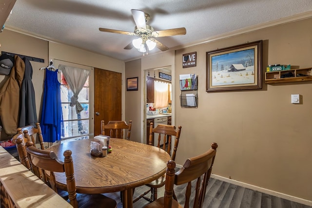 dining space featuring ornamental molding, dark hardwood / wood-style floors, ceiling fan, and a textured ceiling