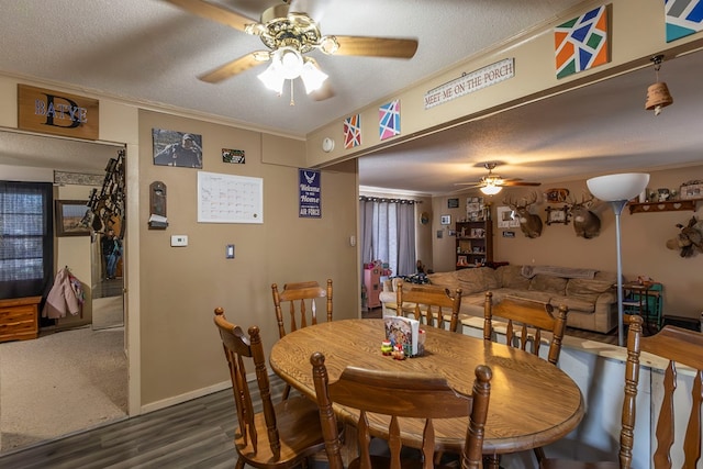 dining area featuring dark hardwood / wood-style flooring, ornamental molding, ceiling fan, and a textured ceiling