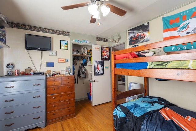 bedroom with light hardwood / wood-style floors, a closet, and ceiling fan