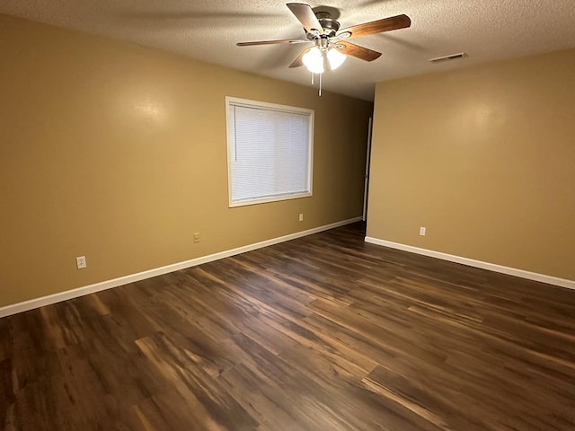 unfurnished room featuring a textured ceiling, ceiling fan, visible vents, baseboards, and dark wood finished floors