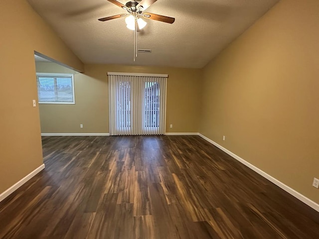 unfurnished room featuring a textured ceiling, baseboards, and dark wood-type flooring