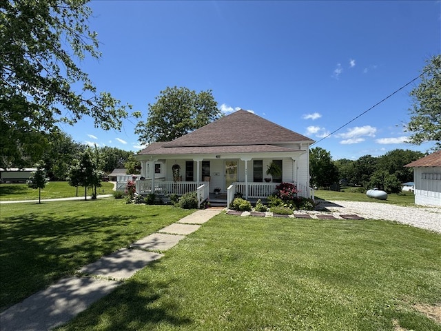411 S Macon St, Bevier, MO 63532 - bungalow-style house featuring a porch, a front lawn, and roof with shingles