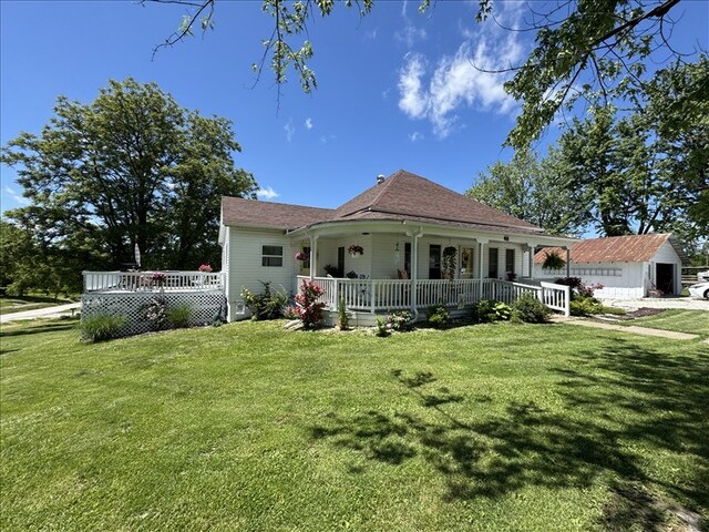 411 S Macon St, Bevier, MO 63532 - view of front of property featuring covered porch, a front lawn, and an outdoor structure