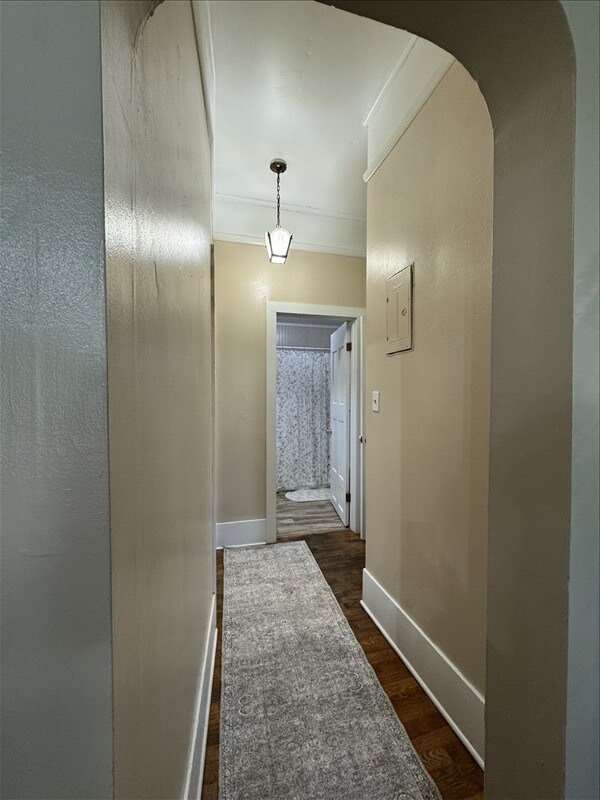 411 S Macon St, Bevier, MO 63532 - hall featuring dark wood-style flooring, baseboards, arched walkways, and ornamental molding