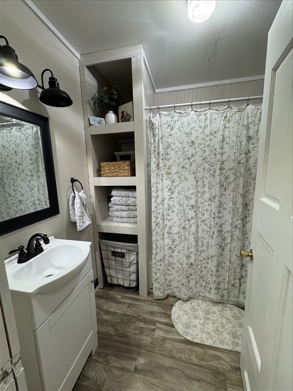 411 S Macon St, Bevier, MO 63532 - full bathroom with vanity, ornamental molding, curtained shower, and built in features