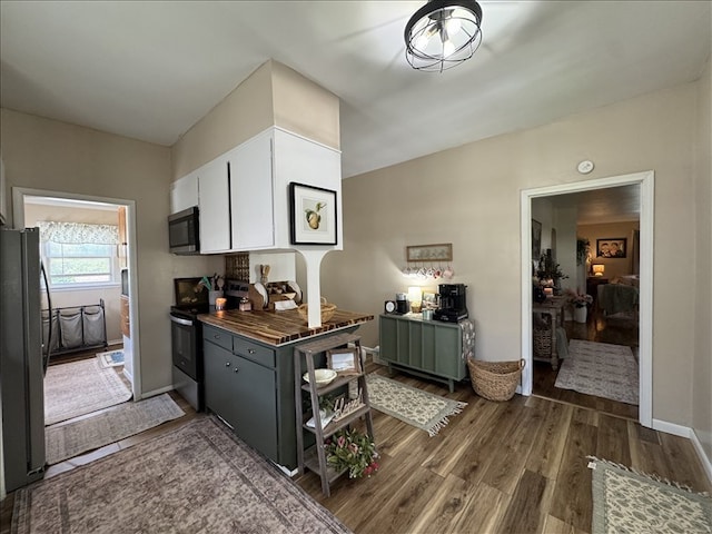 411 S Macon St, Bevier, MO 63532 - kitchen with stainless steel appliances, white cabinets, and dark wood-type flooring