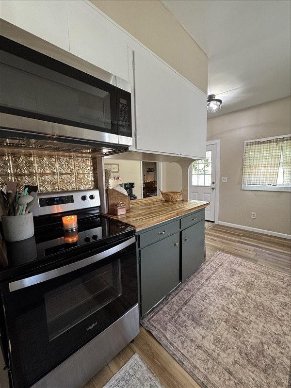 411 S Macon St, Bevier, MO 63532 - kitchen with stainless steel appliances, baseboards, light wood-style flooring, and wooden counters