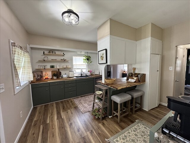 411 S Macon St, Bevier, MO 63532 - kitchen with a sink, dark wood finished floors, gray cabinets, baseboards, and wooden counters