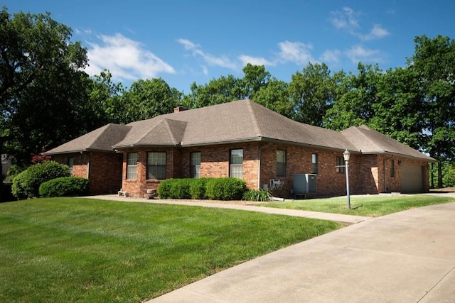 2110 Woodcrest Dr, Chillicothe, MO 64601 - view of front of home featuring an attached garage, a front yard, brick siding, and driveway
