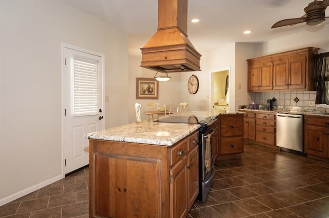 2110 Woodcrest Dr, Chillicothe, MO 64601 - kitchen featuring stainless steel appliances, island range hood, ceiling fan, brown cabinetry, and backsplash
