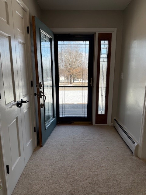 doorway to outside with light colored carpet and a baseboard heating unit