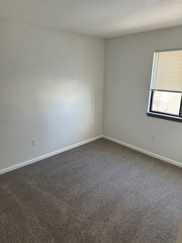 706 Woodwinds Ct, Kirksville, MO 63501 - spare room with baseboards, a textured ceiling, and carpet