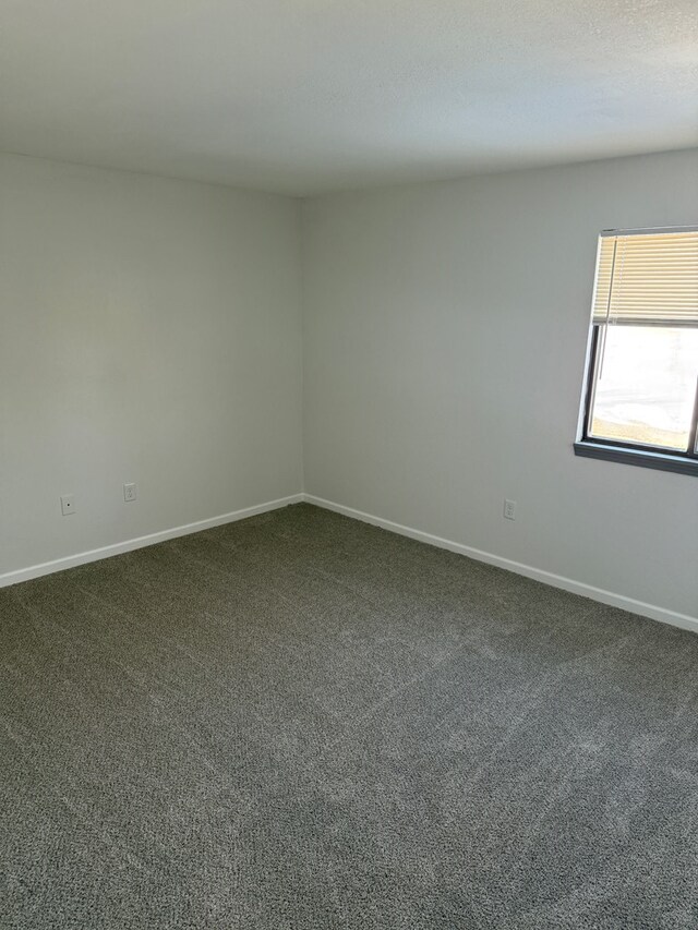 706 Woodwinds Ct, Kirksville, MO 63501 - spare room featuring baseboards and dark colored carpet