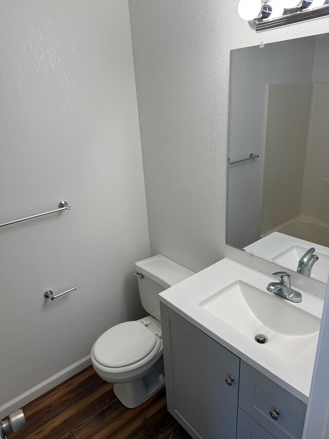 706 Woodwinds Ct, Kirksville, MO 63501 - bathroom featuring baseboards, toilet, wood finished floors, and vanity