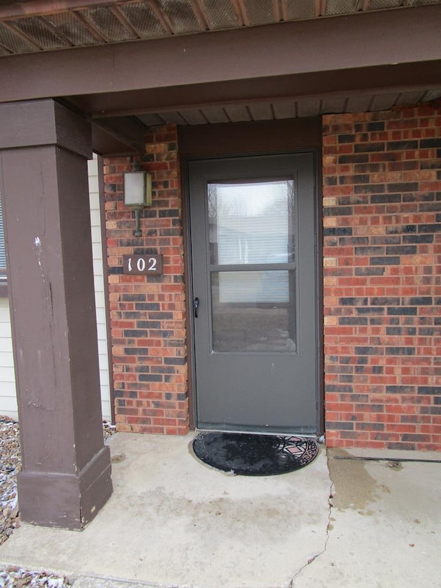 doorway to property featuring brick siding