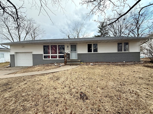 ranch-style house with concrete driveway, brick siding, a front lawn, and an attached garage