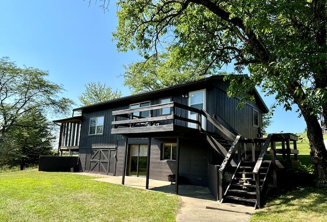 rear view of house featuring a patio, a wooden deck, and a lawn