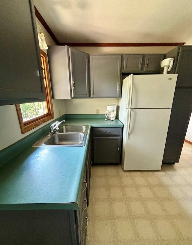 kitchen featuring gray cabinetry, sink, and white fridge