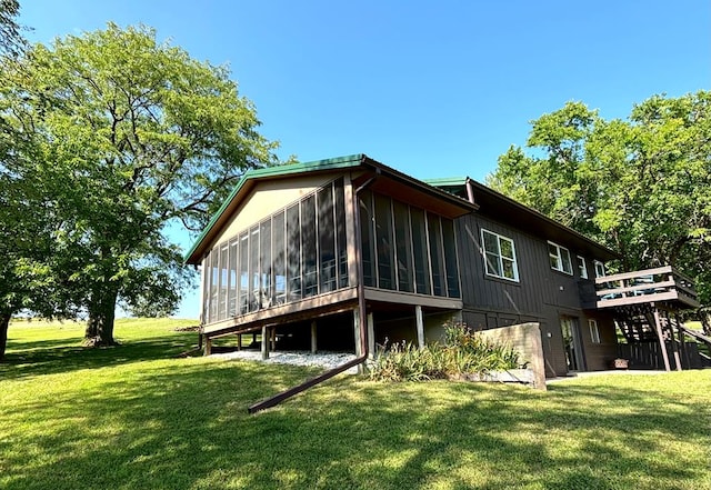 rear view of property with a sunroom and a lawn