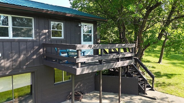 wooden terrace featuring a lawn and a patio area