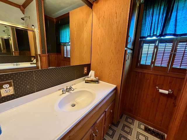 bathroom with ornamental molding, vanity, walk in shower, and wooden walls