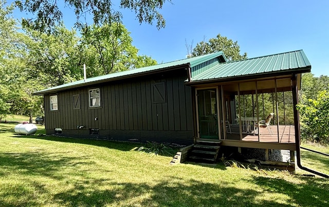 back of property with a wooden deck and a lawn