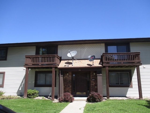 view of front facade with a balcony and a front lawn