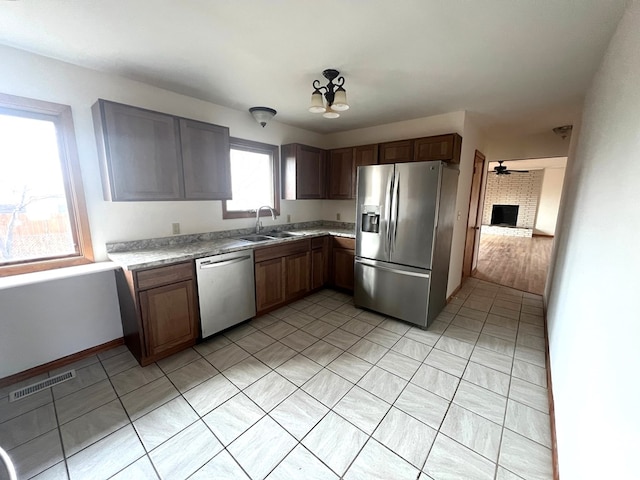 kitchen with ceiling fan, appliances with stainless steel finishes, sink, and light tile patterned floors