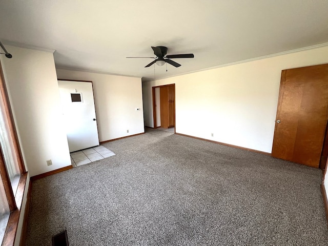 carpeted spare room featuring crown molding and ceiling fan