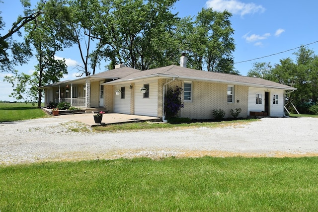 ranch-style house featuring covered porch and a front lawn