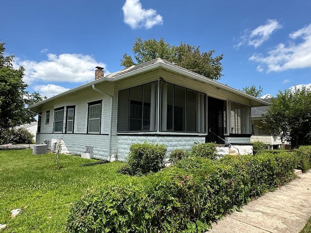 exterior space with cooling unit and a front lawn