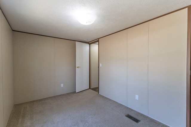 1018 Logue Ln, Keytesville, MO 65261 - unfurnished room with visible vents, light colored carpet, and a textured ceiling