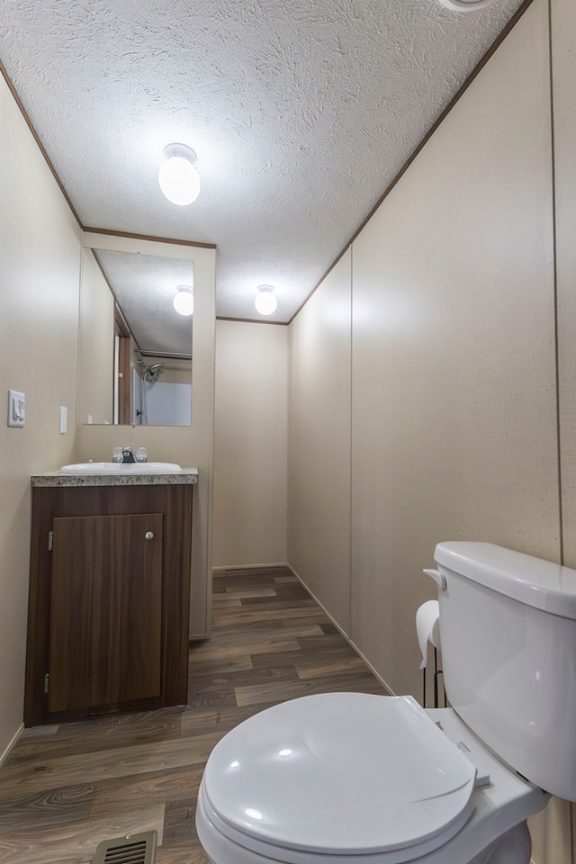 1018 Logue Ln, Keytesville, MO 65261 - bathroom featuring vanity, a textured ceiling, toilet, visible vents, and wood finished floors