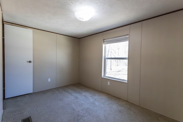 1018 Logue Ln, Keytesville, MO 65261 - carpeted spare room featuring visible vents, a textured ceiling, and ornamental molding