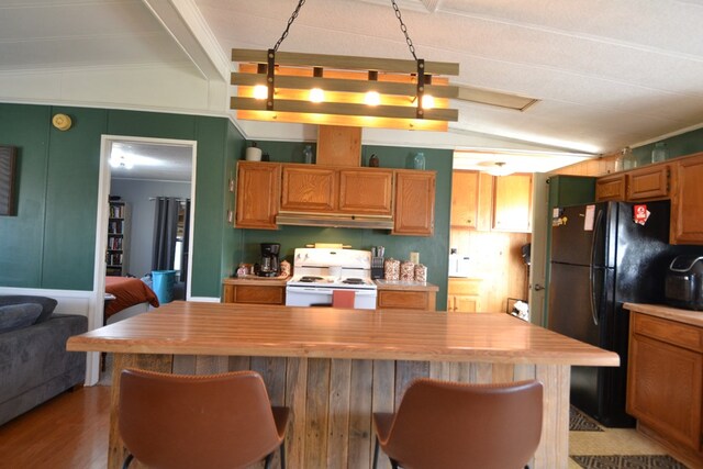 49615 Peach Rd, Milan, MO 63556 - kitchen featuring white electric range oven, freestanding refrigerator, under cabinet range hood, a kitchen breakfast bar, and a kitchen island