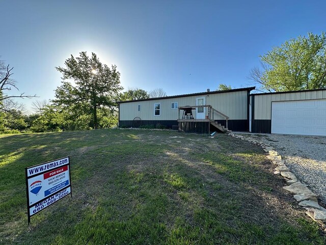 49615 Peach Rd, Milan, MO 63556 - view of front facade with a garage, a deck, and a front yard