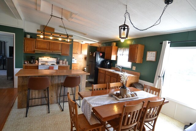 49615 Peach Rd, Milan, MO 63556 - kitchen featuring white appliances, vaulted ceiling, brown cabinets, a sink, and a kitchen island
