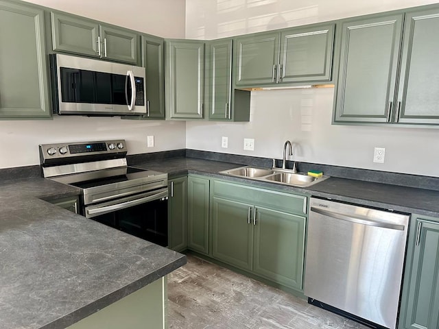 kitchen featuring appliances with stainless steel finishes, sink, and green cabinetry