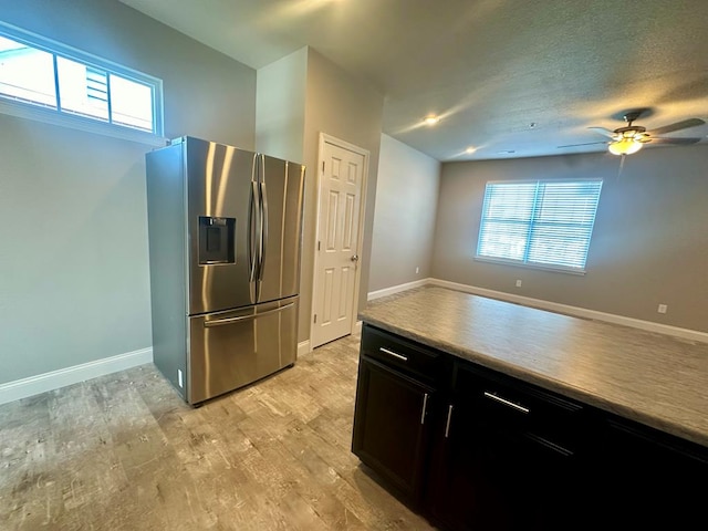 kitchen featuring a healthy amount of sunlight, light hardwood / wood-style flooring, ceiling fan, and stainless steel fridge