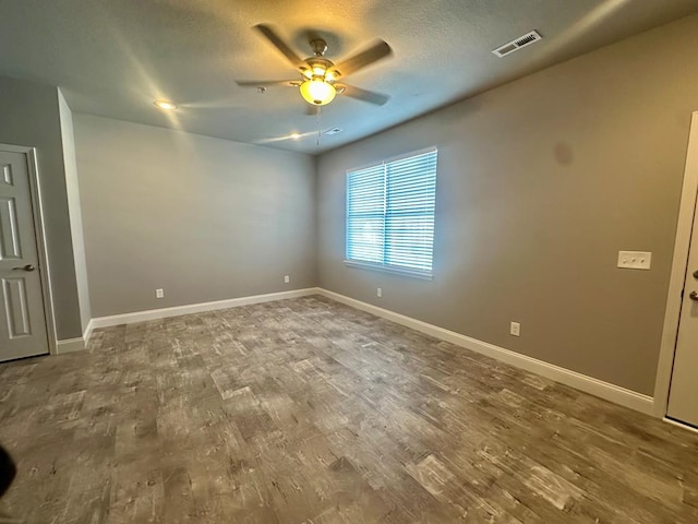 unfurnished room with a textured ceiling, hardwood / wood-style flooring, and ceiling fan