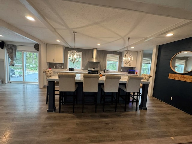 501 SE State St, Milan, MO 63556 - kitchen with light countertops, wall chimney exhaust hood, a chandelier, white cabinets, and a wealth of natural light