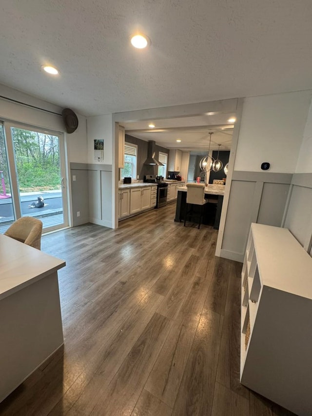 501 SE State St, Milan, MO 63556 - living room with a healthy amount of sunlight, a decorative wall, dark wood-style floors, and a notable chandelier