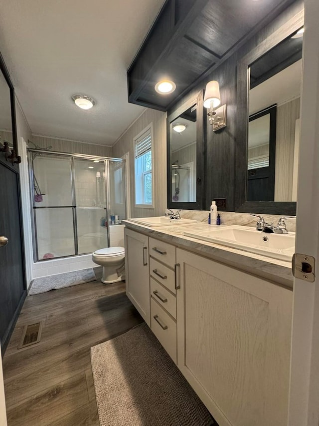 501 SE State St, Milan, MO 63556 - bathroom featuring visible vents, wood finished floors, toilet, a sink, and a stall shower