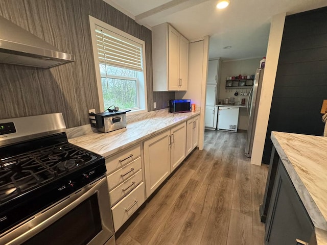 501 SE State St, Milan, MO 63556 - kitchen featuring white cabinetry, appliances with stainless steel finishes, wood finished floors, and extractor fan