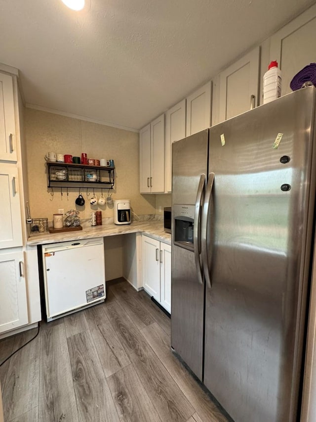 501 SE State St, Milan, MO 63556 - kitchen featuring white dishwasher, light countertops, stainless steel fridge, white cabinetry, and dark wood-type flooring