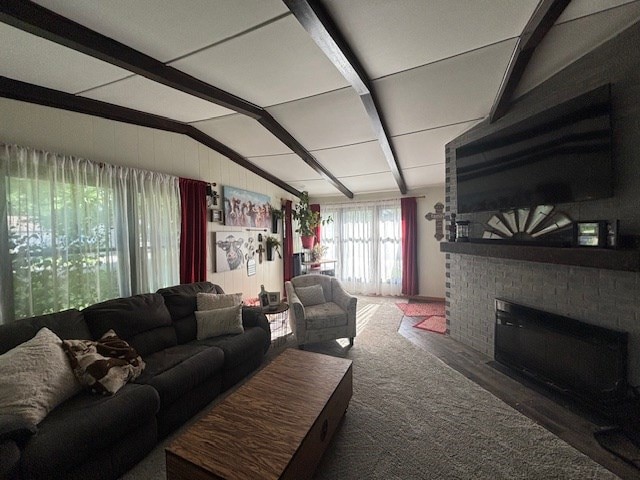 1715 E Mcpherson St, Kirksville, MO 63501 - carpeted living room featuring vaulted ceiling with beams and a brick fireplace